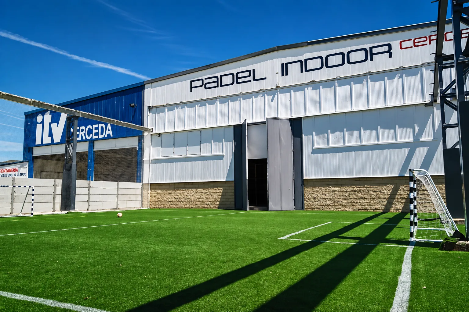 Zona exterior en la parte trasera del club, con césped artificial y portería de fútbol